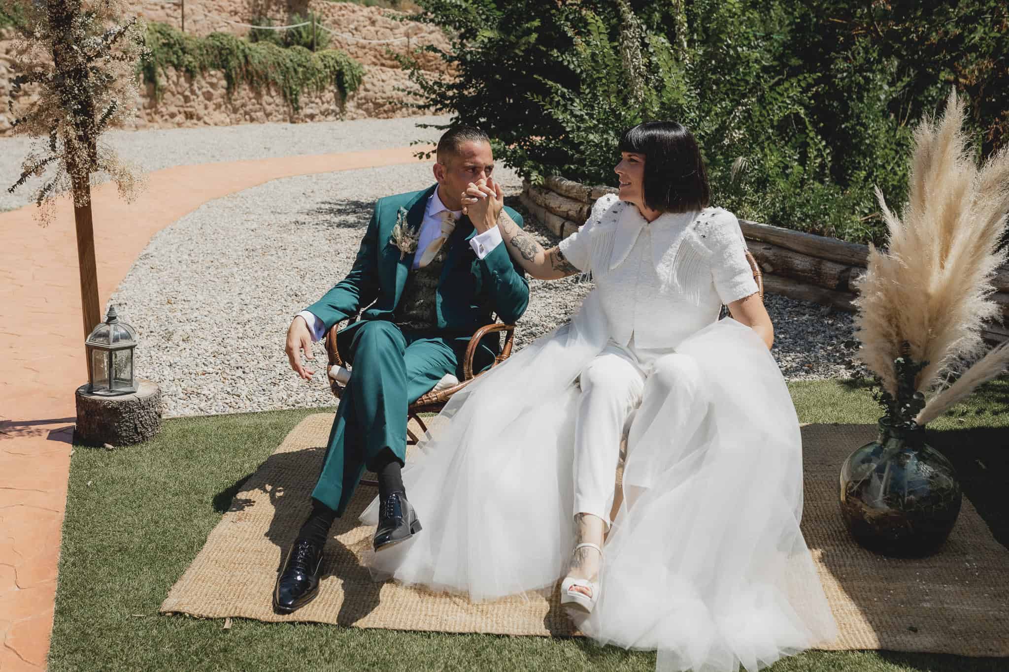 Una pareja de recién casados en un momento emotivo, rodeados de naturaleza, en un entorno elegante y bohemio.